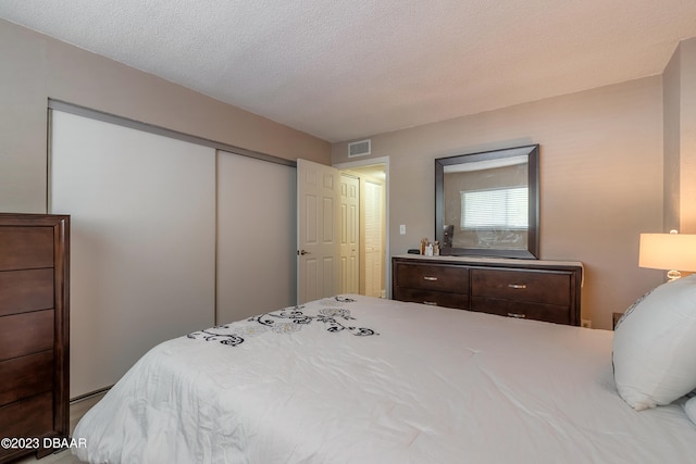 bedroom with a textured ceiling and a closet