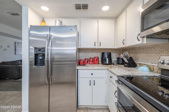1052 Tompkins Dr, Port Orange, FL 32129 - kitchen with appliances with stainless steel finishes, white cabinetry, backsplash, and recessed lighting
