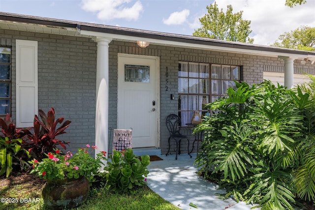 1052 Tompkins Dr, Port Orange, FL 32129 - doorway to property featuring brick siding and a porch