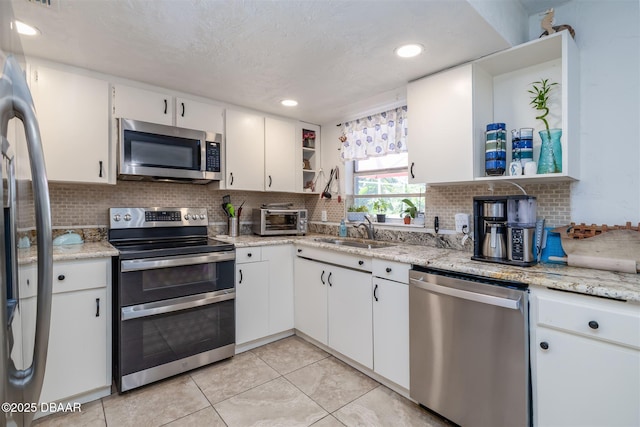 1052 Tompkins Dr, Port Orange, FL 32129 - kitchen with appliances with stainless steel finishes, open shelves, white cabinets, decorative backsplash, and recessed lighting