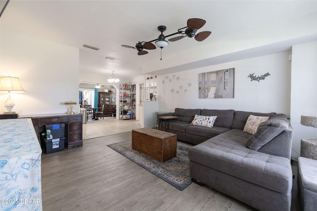1052 Tompkins Dr, Port Orange, FL 32129 - living room featuring a ceiling fan, wood finished floors, and a chandelier