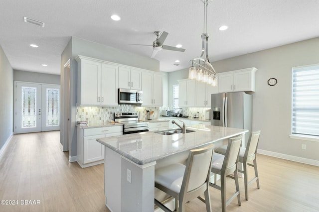 kitchen with white cabinets, appliances with stainless steel finishes, a healthy amount of sunlight, and sink