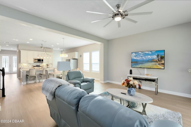 living room with french doors, light hardwood / wood-style flooring, and ceiling fan