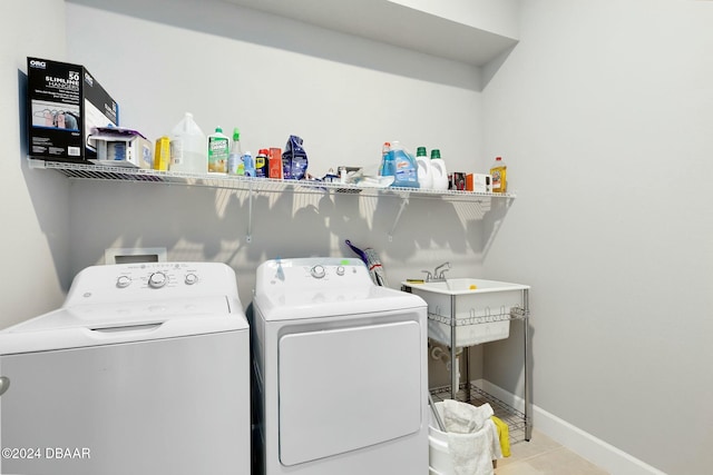 laundry room featuring washer and clothes dryer and light tile patterned floors