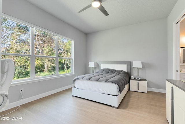 bedroom featuring multiple windows, ceiling fan, and light hardwood / wood-style flooring