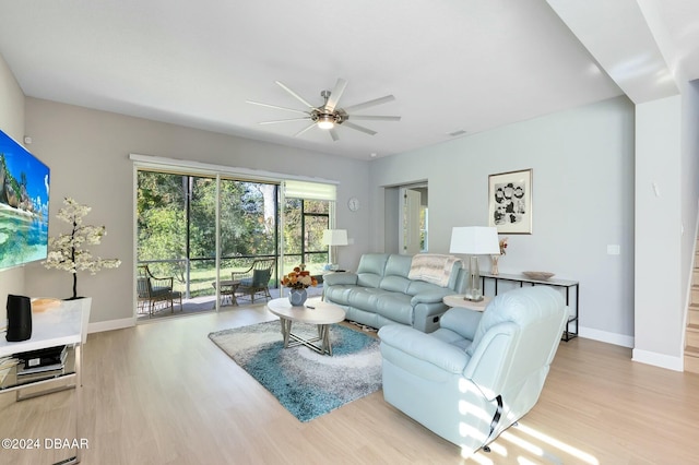 living room with light hardwood / wood-style floors and ceiling fan