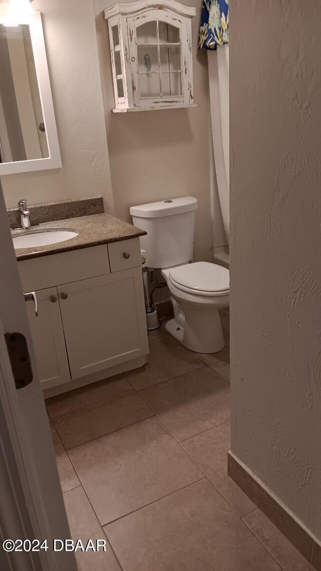 bathroom featuring toilet, vanity, and tile patterned floors