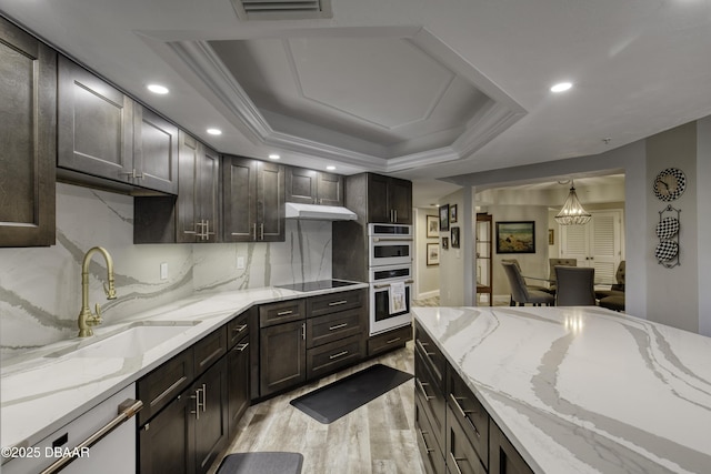 1 John Anderson Dr Unit 103, Ormond Beach, FL 32176 - kitchen featuring light wood-type flooring, recessed lighting, light stone countertops, black electric stovetop, and dark brown cabinets