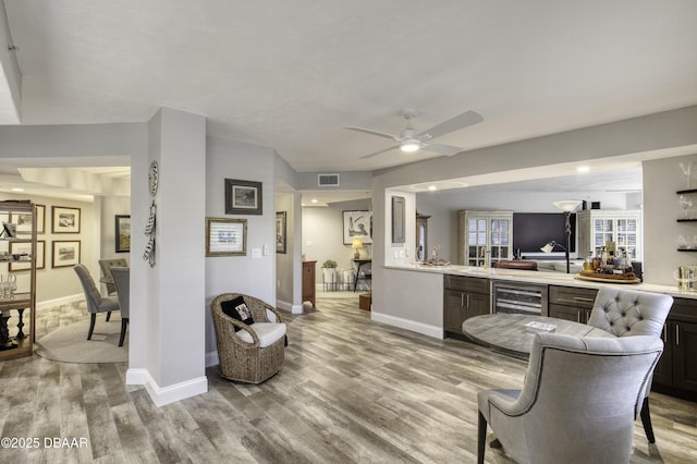 1 John Anderson Dr Unit 103, Ormond Beach, FL 32176 - living area featuring light wood-style flooring, bar, wine cooler, and ceiling fan