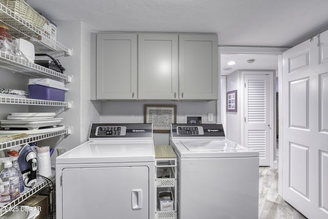 1 John Anderson Dr Unit 103, Ormond Beach, FL 32176 - laundry room with independent washer and dryer, cabinet space, and light wood-type flooring