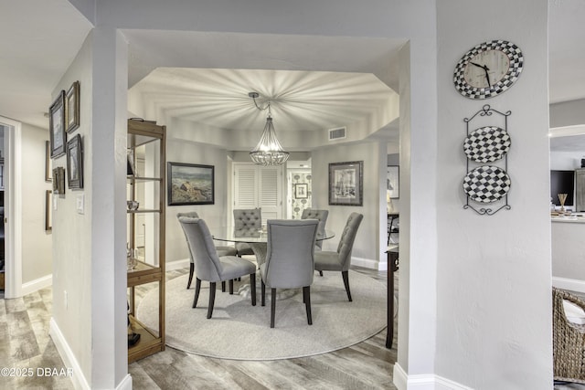 1 John Anderson Dr Unit 103, Ormond Beach, FL 32176 - dining area featuring a chandelier and wood finished floors