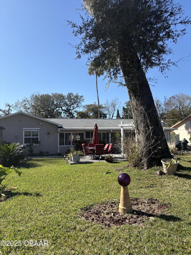 back of property featuring a patio and a yard