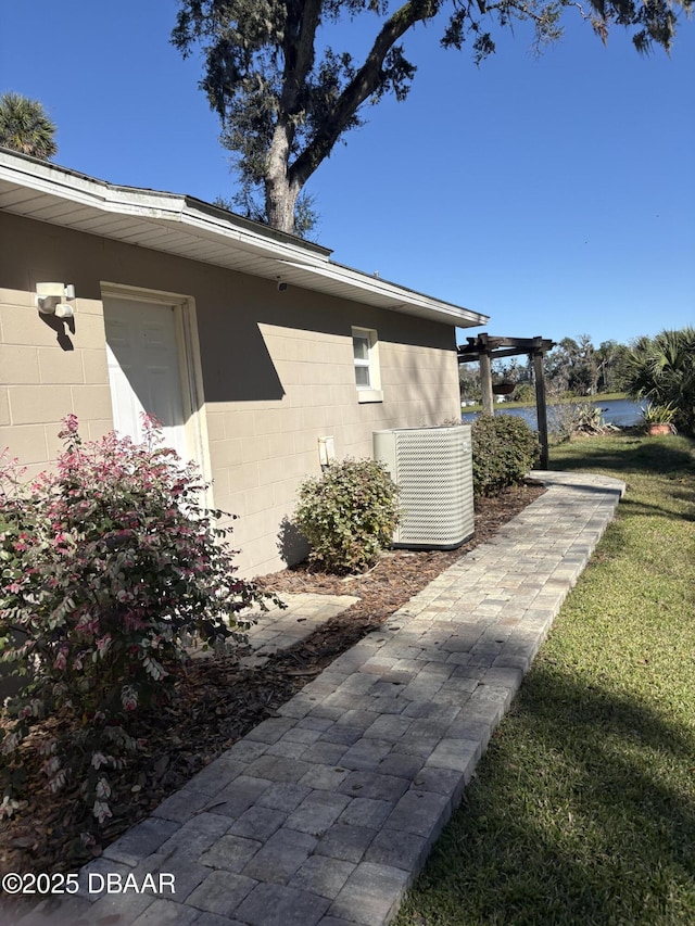 view of side of property featuring a yard and central AC unit