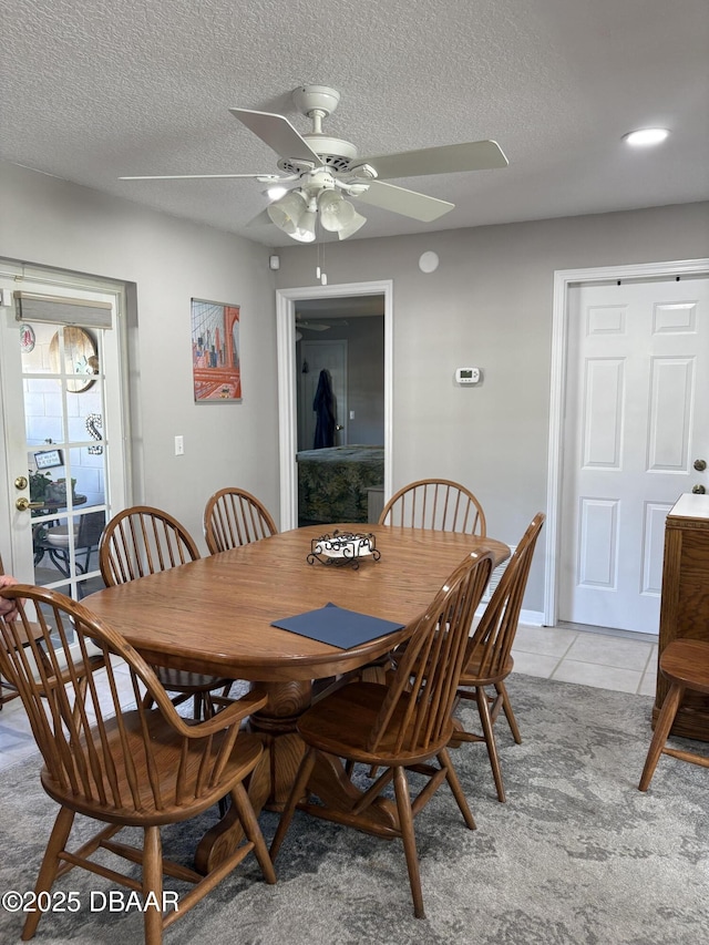 dining space featuring ceiling fan, a textured ceiling, and light tile patterned floors