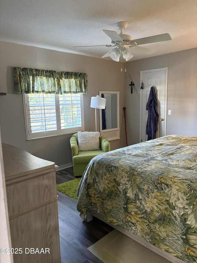 bedroom featuring dark wood-type flooring, ceiling fan, and a textured ceiling