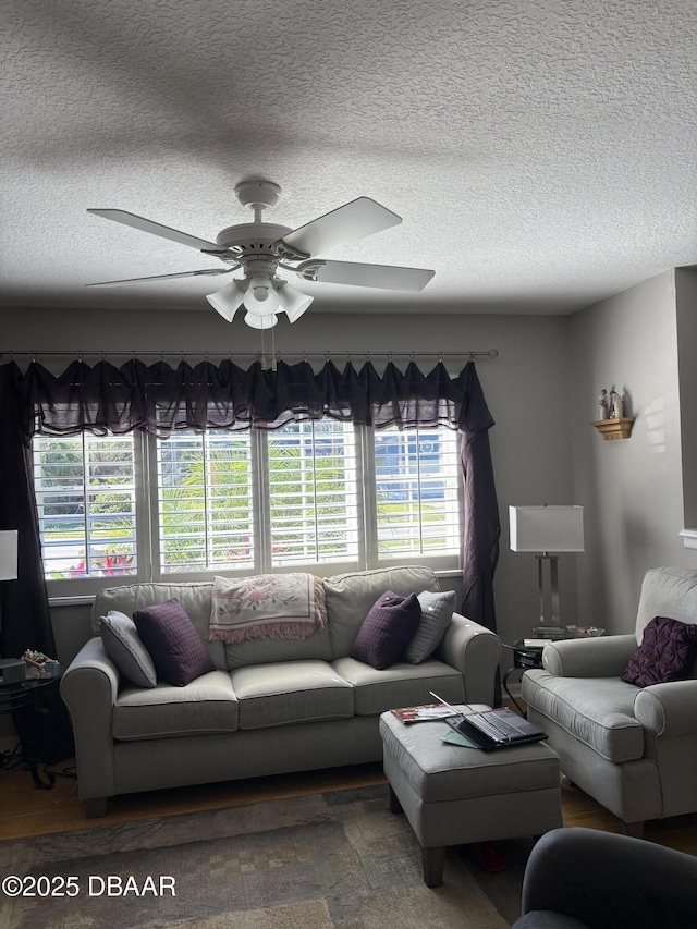 living room with a textured ceiling and ceiling fan