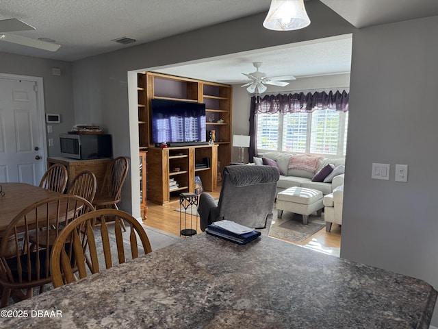 dining area with a textured ceiling and ceiling fan