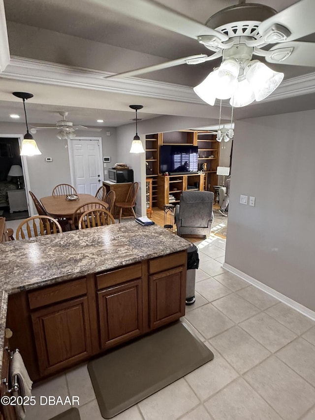 kitchen with light tile patterned flooring, ceiling fan, and dark stone counters