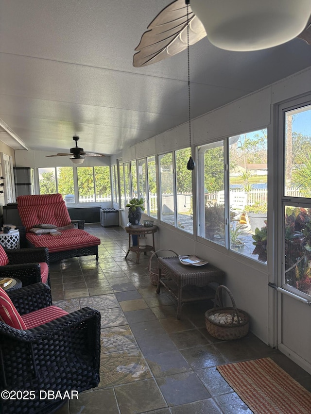 sunroom featuring ceiling fan and a healthy amount of sunlight