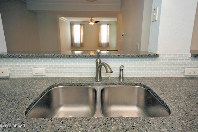 kitchen with tasteful backsplash, sink, and stone countertops