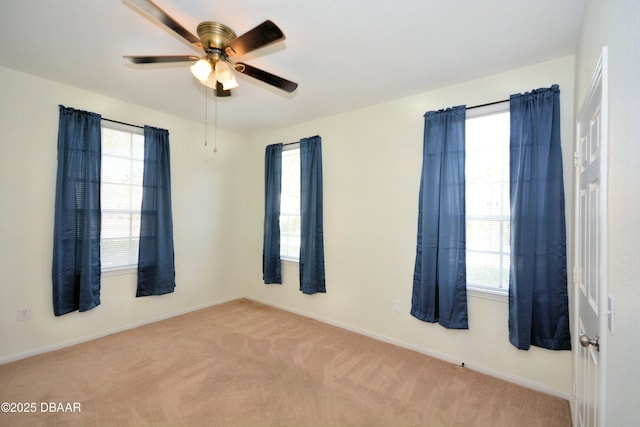 carpeted spare room with ceiling fan