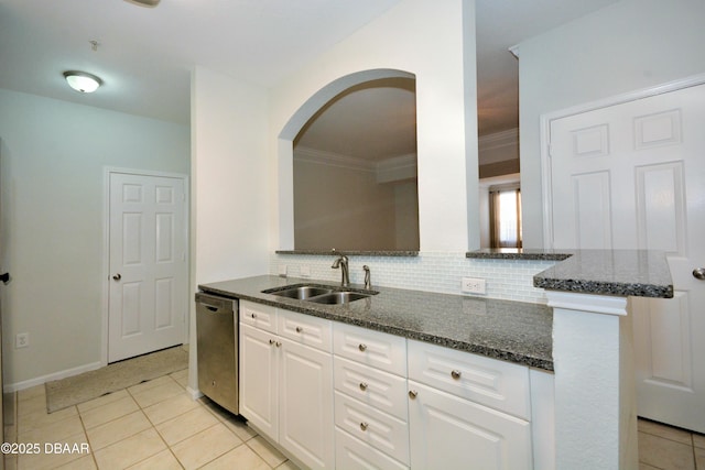 kitchen with sink, white cabinetry, stainless steel dishwasher, dark stone counters, and backsplash