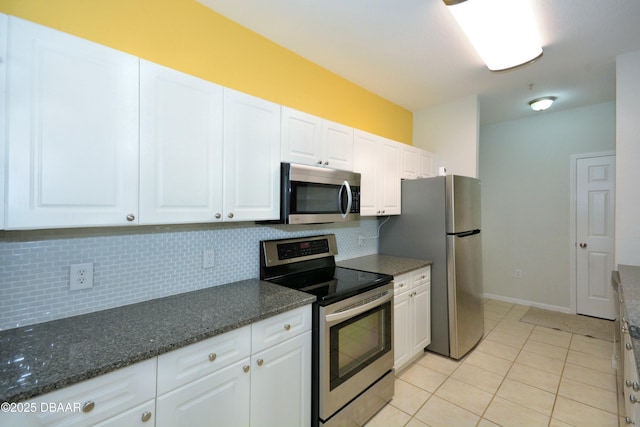 kitchen featuring white cabinetry, stainless steel appliances, tasteful backsplash, and dark stone counters