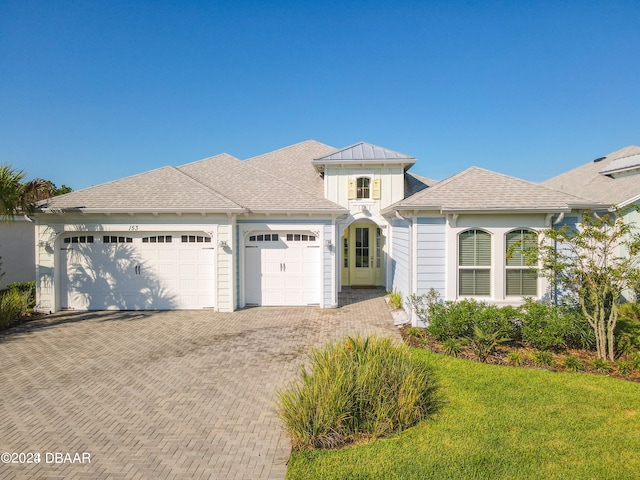 view of front of property featuring a garage and a front lawn