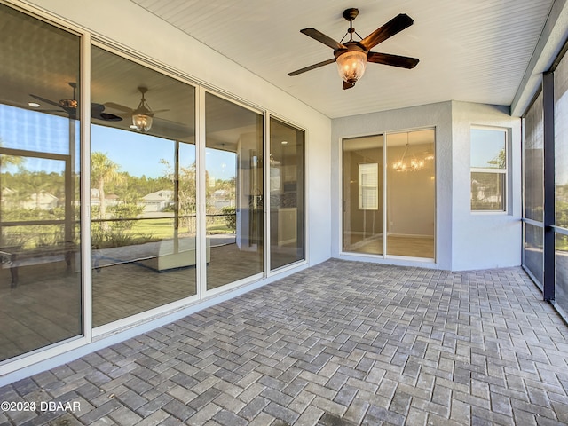 unfurnished sunroom with ceiling fan