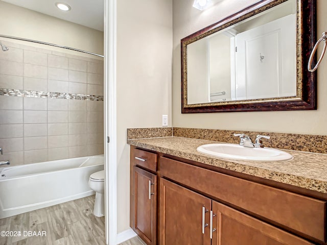 full bathroom featuring tiled shower / bath, toilet, and vanity