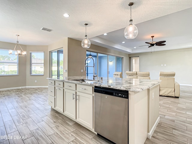 kitchen with decorative light fixtures, sink, white cabinets, dishwasher, and a kitchen island with sink