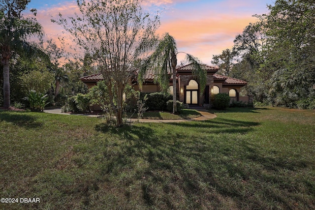 mediterranean / spanish-style house featuring a lawn