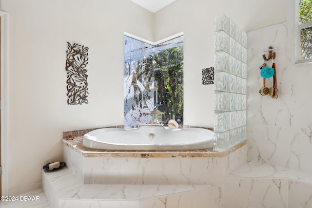 bathroom with tiled bath and plenty of natural light