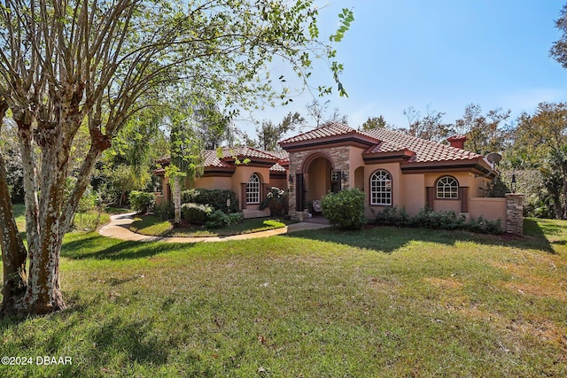 mediterranean / spanish-style home with a front lawn