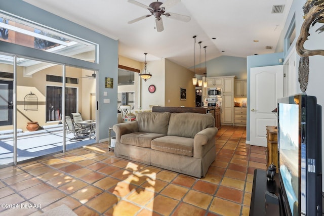 living room with ceiling fan, dark tile patterned floors, and lofted ceiling