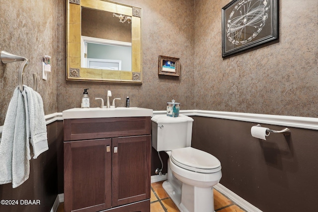 bathroom with toilet, vanity, and tile patterned floors