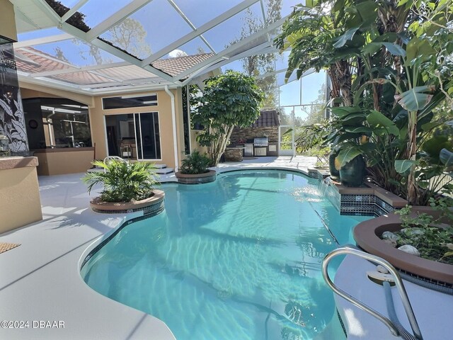 view of swimming pool with a lanai, pool water feature, and a patio