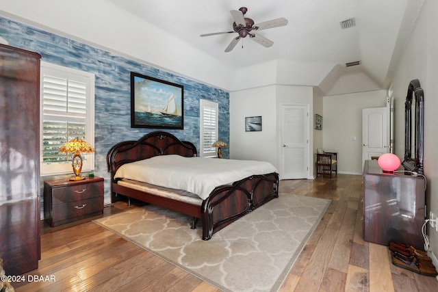 bedroom featuring multiple windows, ceiling fan, vaulted ceiling, and hardwood / wood-style flooring