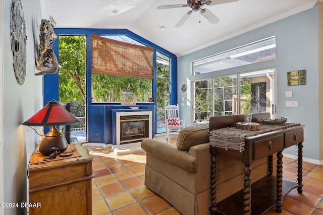 living area with tile patterned floors, ceiling fan, ornamental molding, and vaulted ceiling