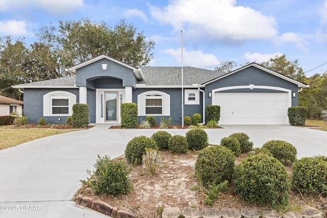 single story home with a garage, driveway, a shingled roof, and stucco siding