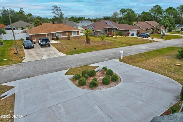 exterior space featuring a residential view, driveway, and fence