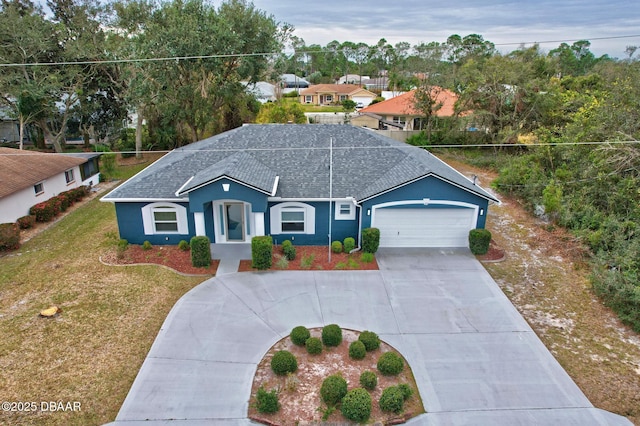 ranch-style house featuring driveway, a shingled roof, an attached garage, a front lawn, and stucco siding