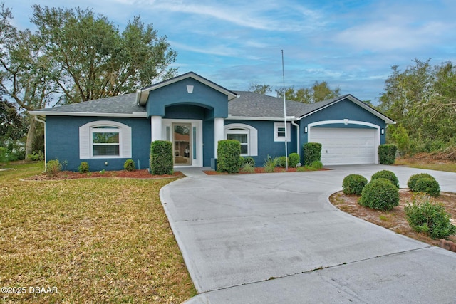 ranch-style home featuring an attached garage, a front lawn, concrete driveway, and stucco siding