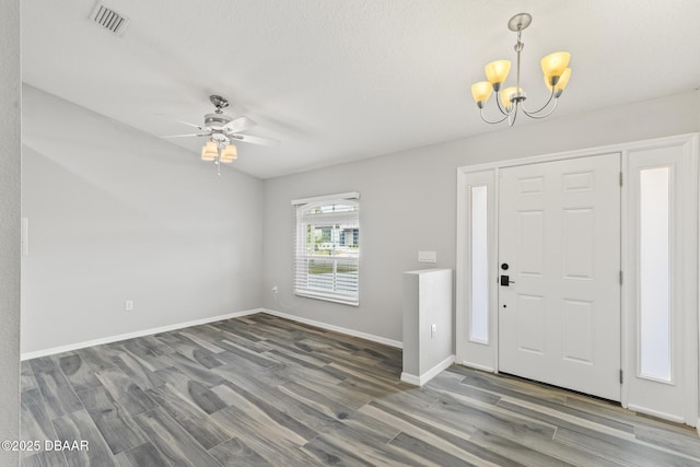 foyer entrance featuring ceiling fan with notable chandelier, visible vents, baseboards, and wood finished floors