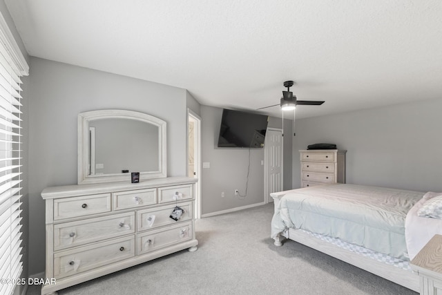 bedroom with a ceiling fan, light colored carpet, and baseboards