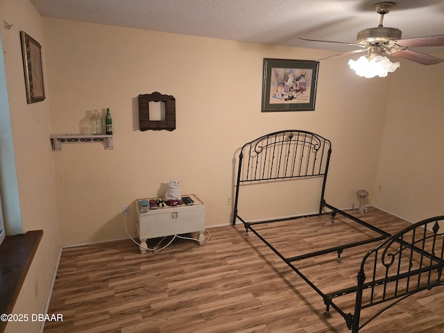 bedroom featuring wood finished floors and a textured ceiling