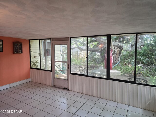 tiled empty room with baseboards and a wealth of natural light