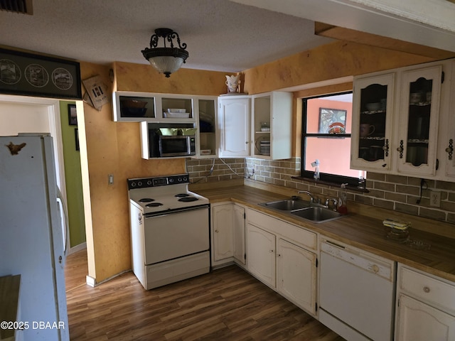 kitchen featuring tasteful backsplash, dark wood-style flooring, a sink, and white appliances