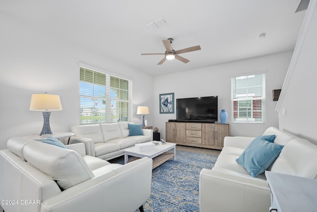 living room featuring tile patterned flooring, a ceiling fan, and visible vents