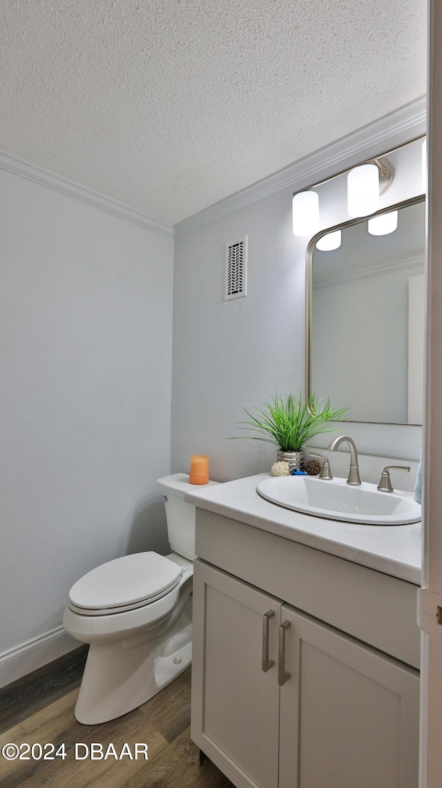 bathroom with hardwood / wood-style floors, vanity, toilet, and a textured ceiling